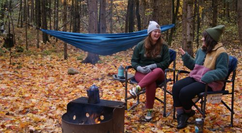 two people sitting on chairs on campsite